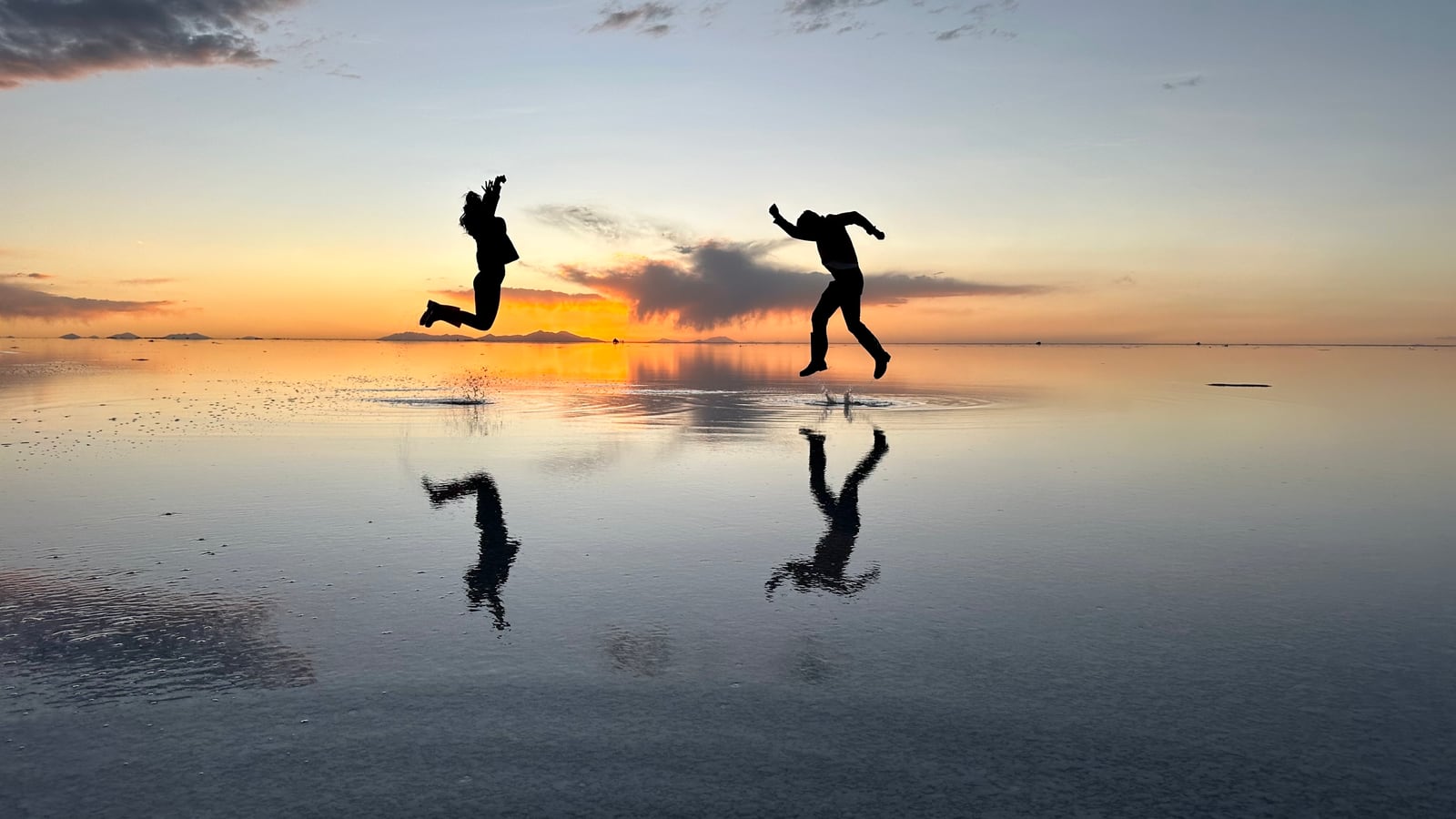 Dois saltos refletidos no espelho de água do salar, ao pôr do sol